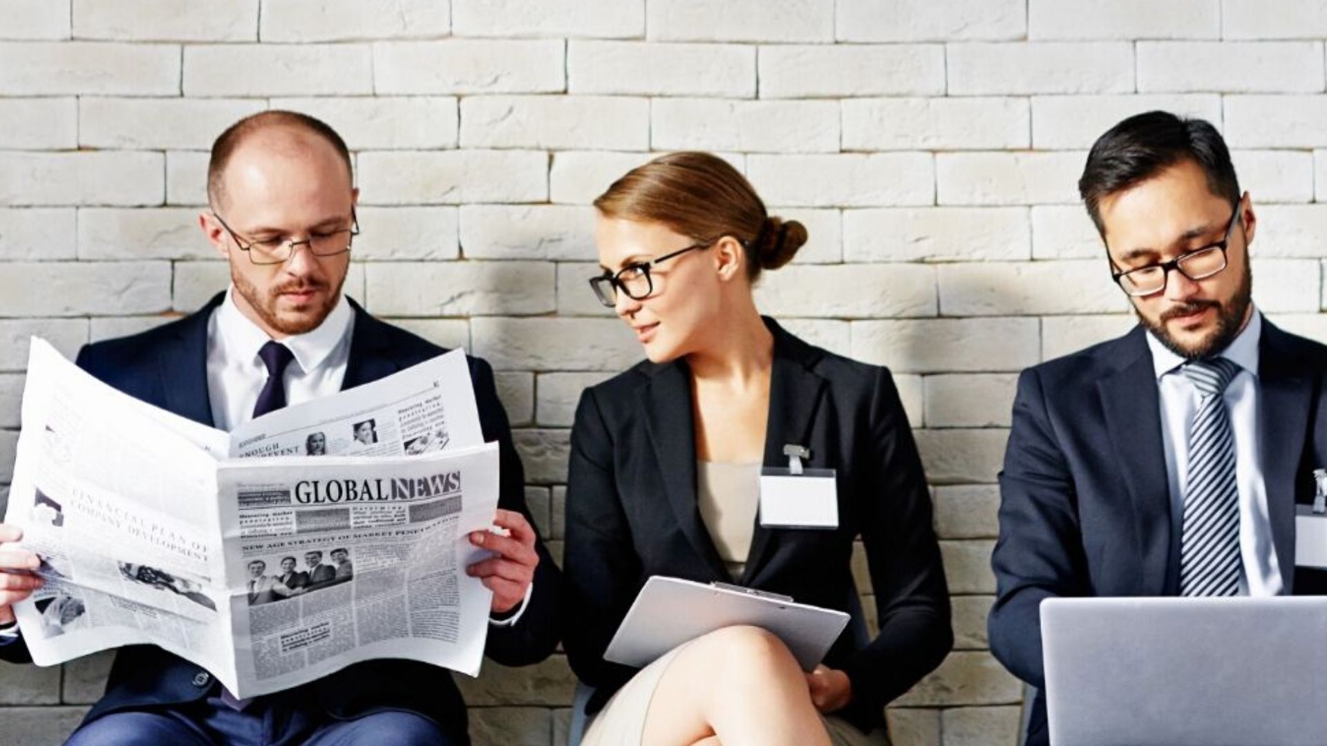 What are hidden disabilities? 3 professionals sit in a row, one reading a paper, one with a laptop and one with a notebook