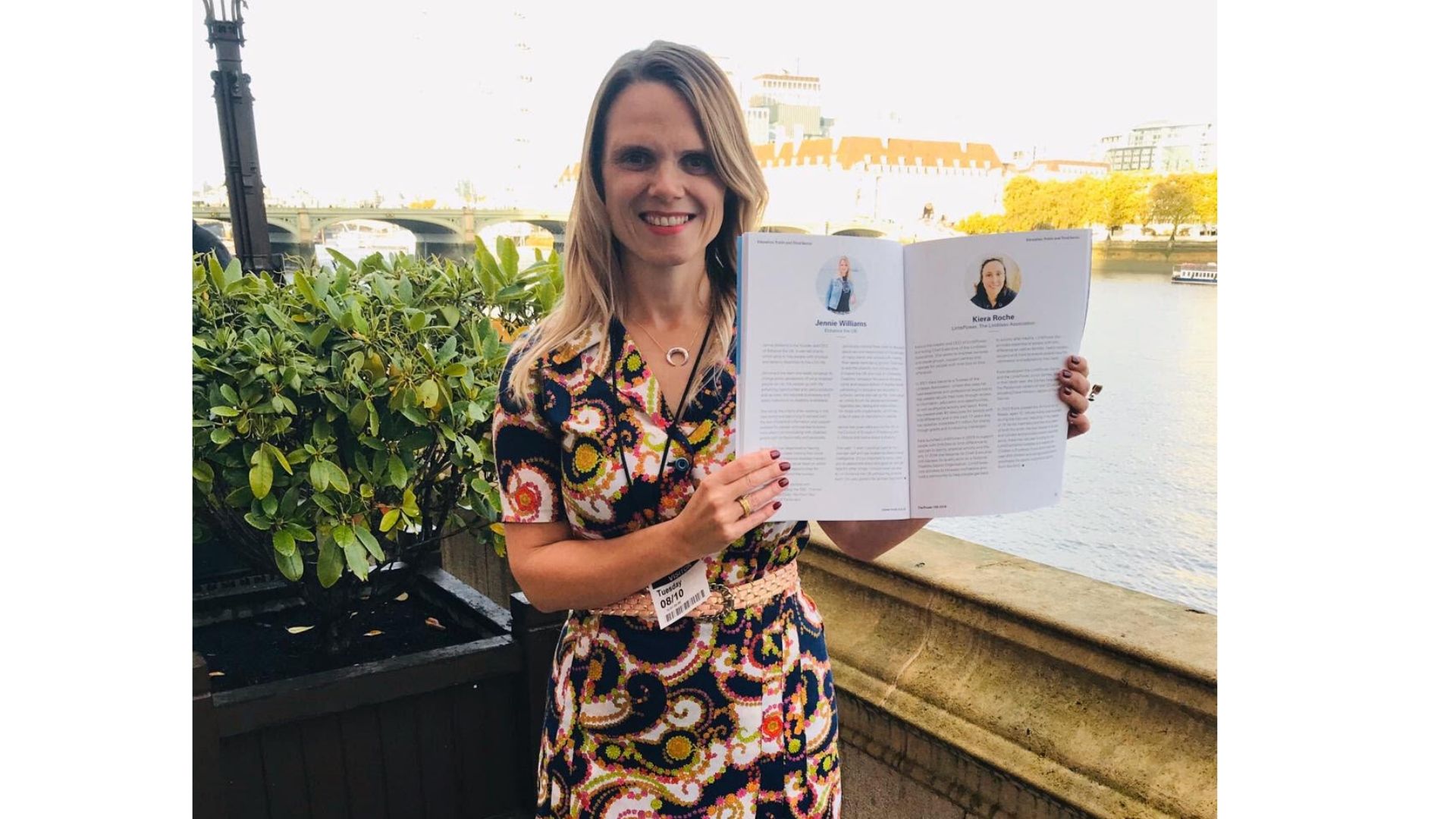 Jennie Williams CEO holds up the Power 100 List brochure whilst standing by the River Thames