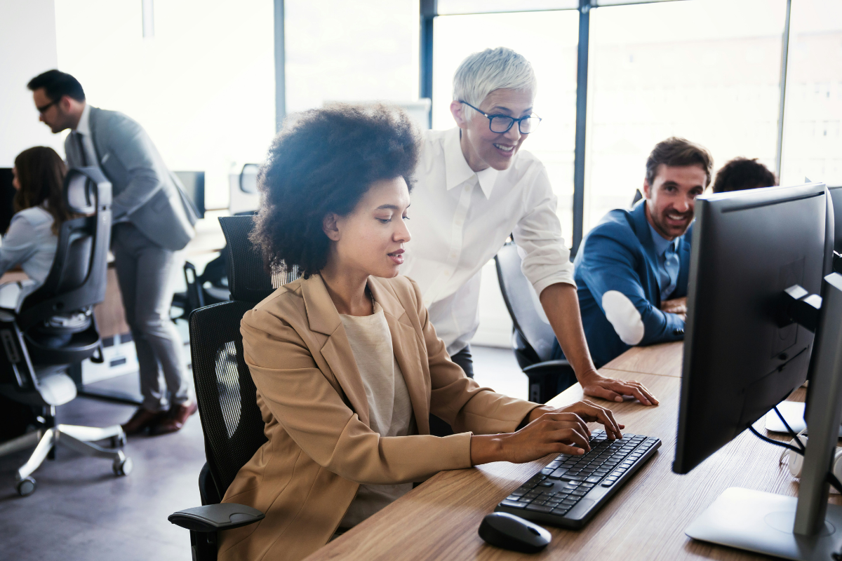 Supporting autistic colleagues in the workplace: Two women sitting at a computer working on a document together